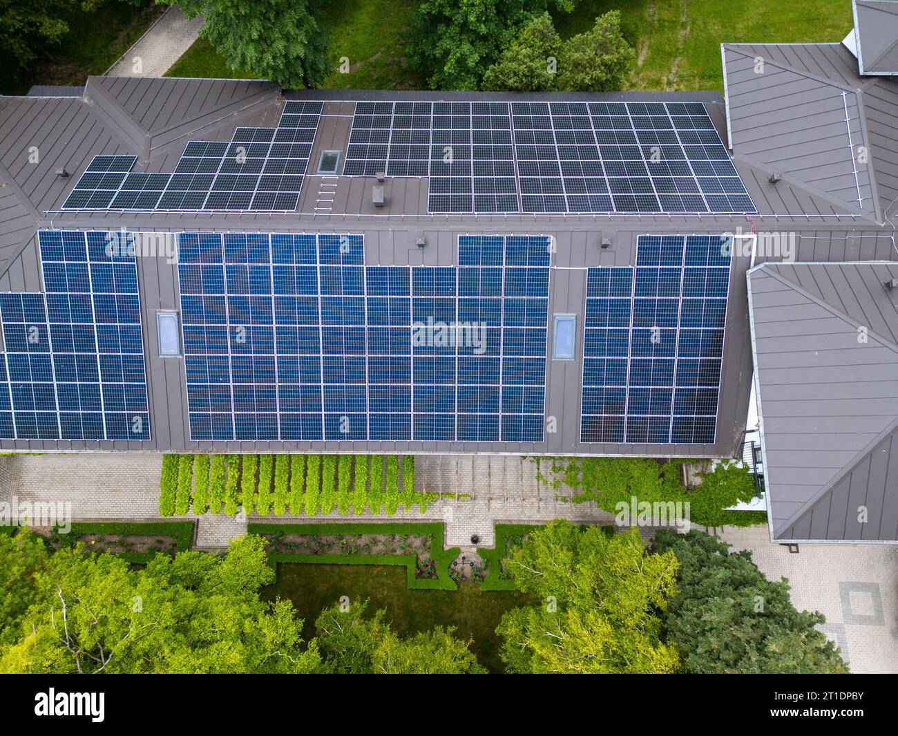 Das moderne Haus mit einem Dach, das als großes Solarmodul entworfen wurde, verbindet Stil und Nachhaltigkeit. Das schlanke und funktionale Design lässt die Sonne perfekt auf sich wirken Stockfoto