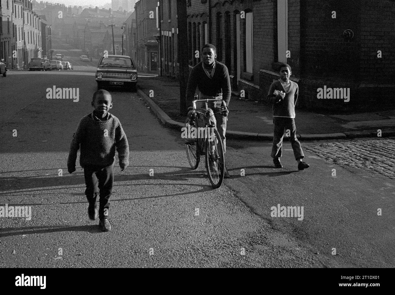 Drei schwarze Jungs, die von einer Einkaufstour auf der Pym Street während der Slumräumung und Abriss des viktorianischen St. Ann's, Nottingham, zurückkehrten. 1969-1972 Stockfoto