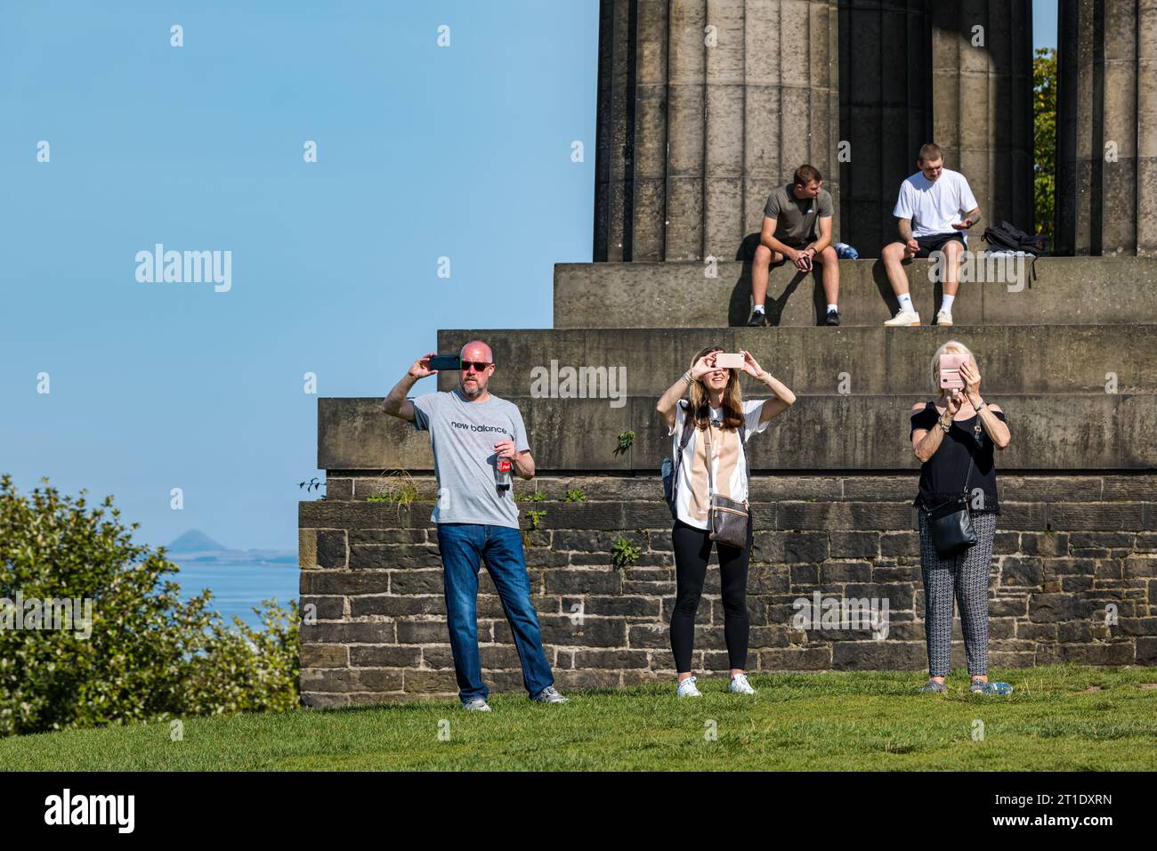 Menschen, die Fotos auf Mobiltelefonen machen, im National Monument, Calton Hill, Edinburgh, Schottland, Großbritannien Stockfoto