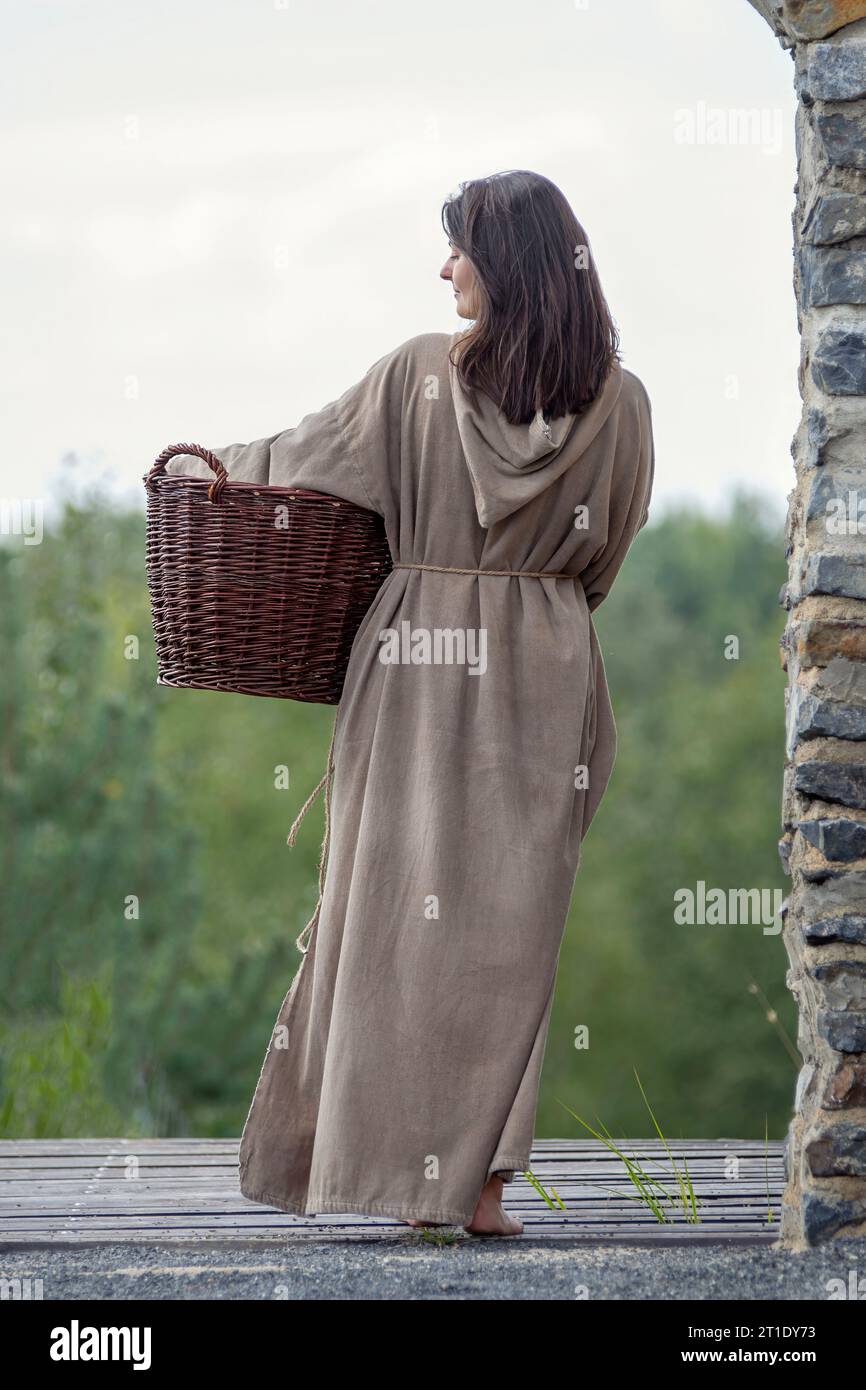 Mittelalterliche Frau im Rückblick mit Korb und langen Haaren Stockfoto
