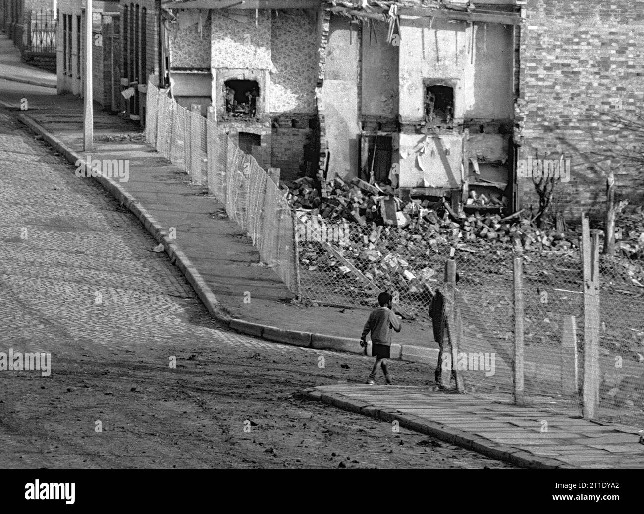 Zwei Jungen, die durch Straßen von abgerissenen Häusern auf dem Weg zur oder von der Schule gehen, während der Slumräumung von St. Ann's, Nottingham.1969-1972, Stockfoto