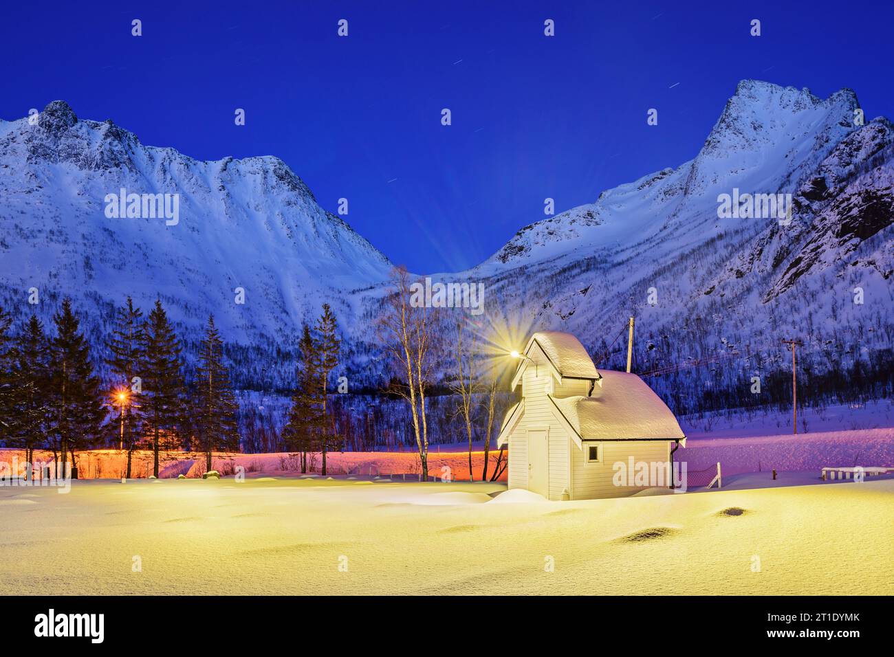 Beleuchtete Kapelle mit Bergen im Hintergrund, Senjahopen, Senja, Troms og Finnmark, Norwegen Stockfoto