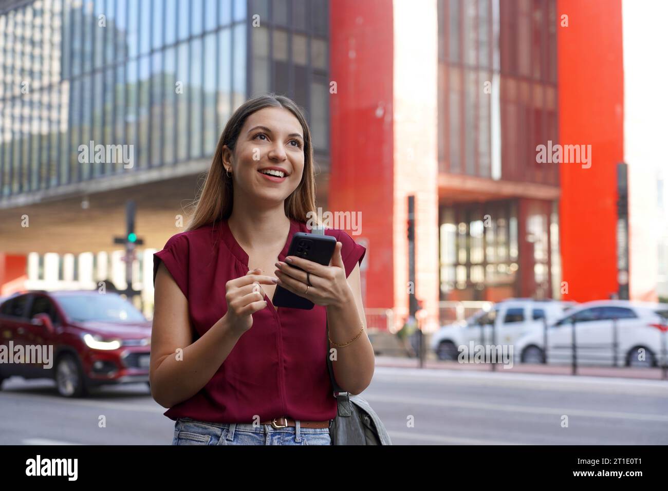 Brasilianische Geschäftsfrau, die ihr Smartphone mit Ringhalter auf der Paulista Avenue in Sao Paulo Megalopolis, Brasilien, nutzt Stockfoto