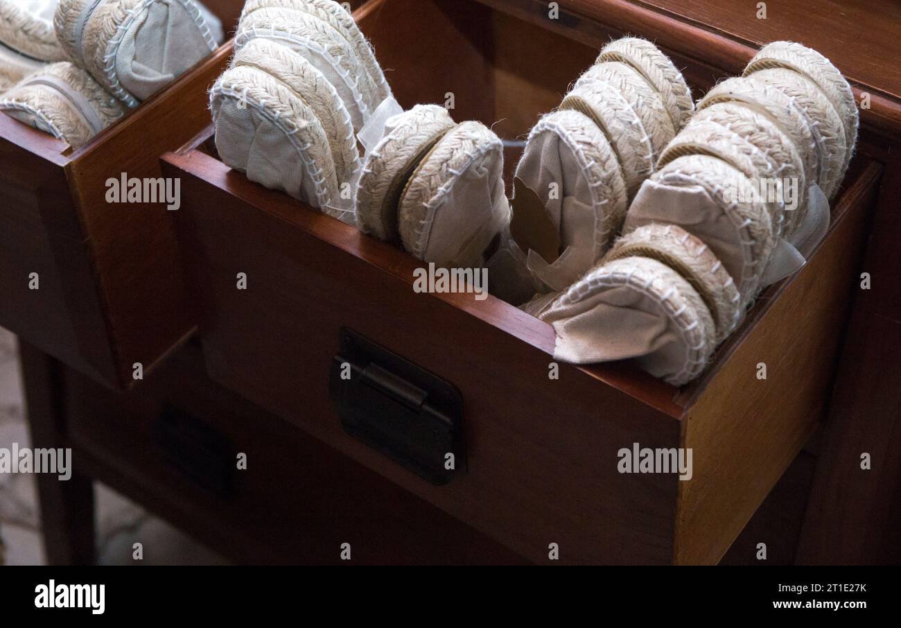 Holzschublade voll mit weißen Espadrille-Schuhen. Einwegschuhe für Hochzeitsgäste Stockfoto