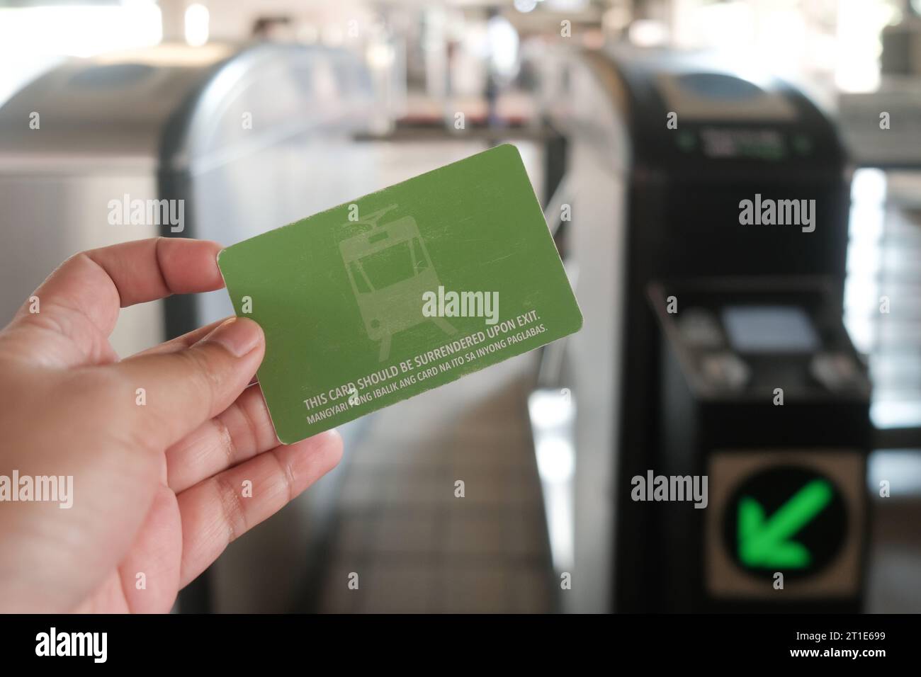Manila, Philippinen: Hand hält Light Rail Transit, 1 Einzelfahrkarte vor Taschautomaten. Nahaufnahme des Einmalfahrscheins der LRT-Linie 1. Stockfoto