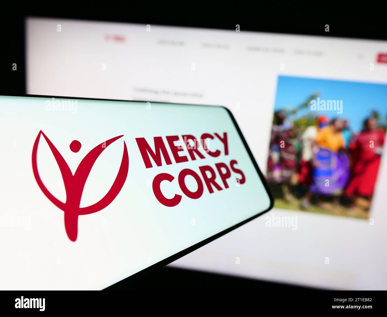 Handy mit Logo der amerikanischen humanitären Hilfsorganisation Mercy Corps vor der Website. Fokussieren Sie sich auf die linke Mitte des Telefondisplays. Stockfoto