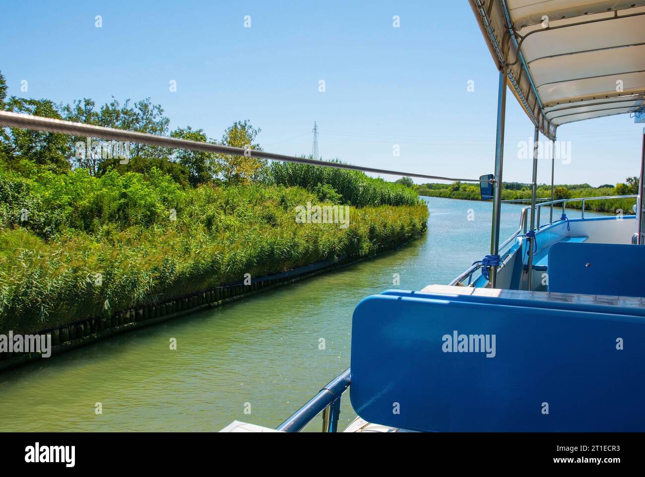 Ein Touristenboot fährt einen Kanal im Grado-Abschnitt der Lagune von Marano und Grado in Friaul-Julisch Venetien, Nordosten Italiens Stockfoto