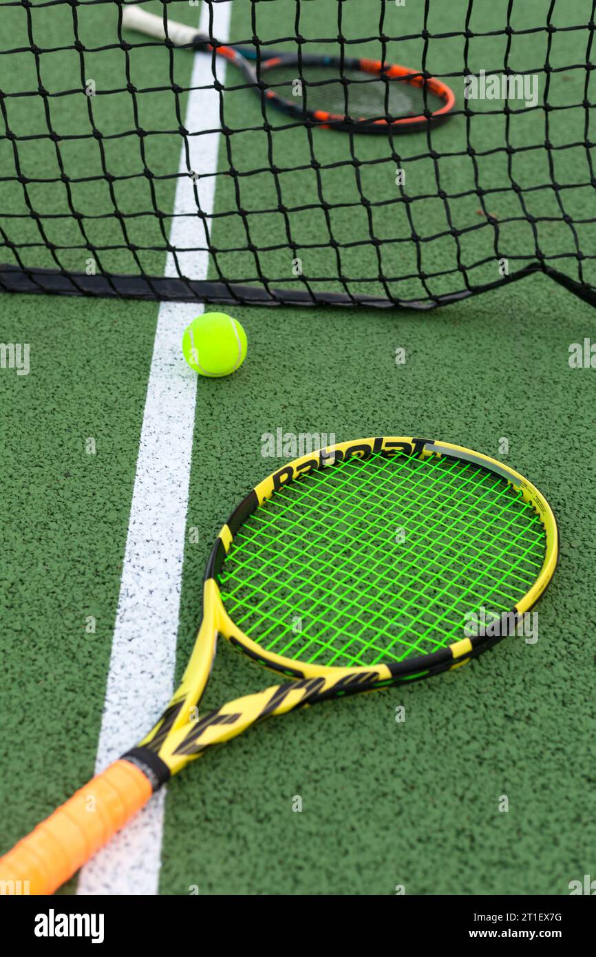 Zwei Schläger auf jeder Seite des Netzes und ein Ball in der Nähe der Linie Stockfoto