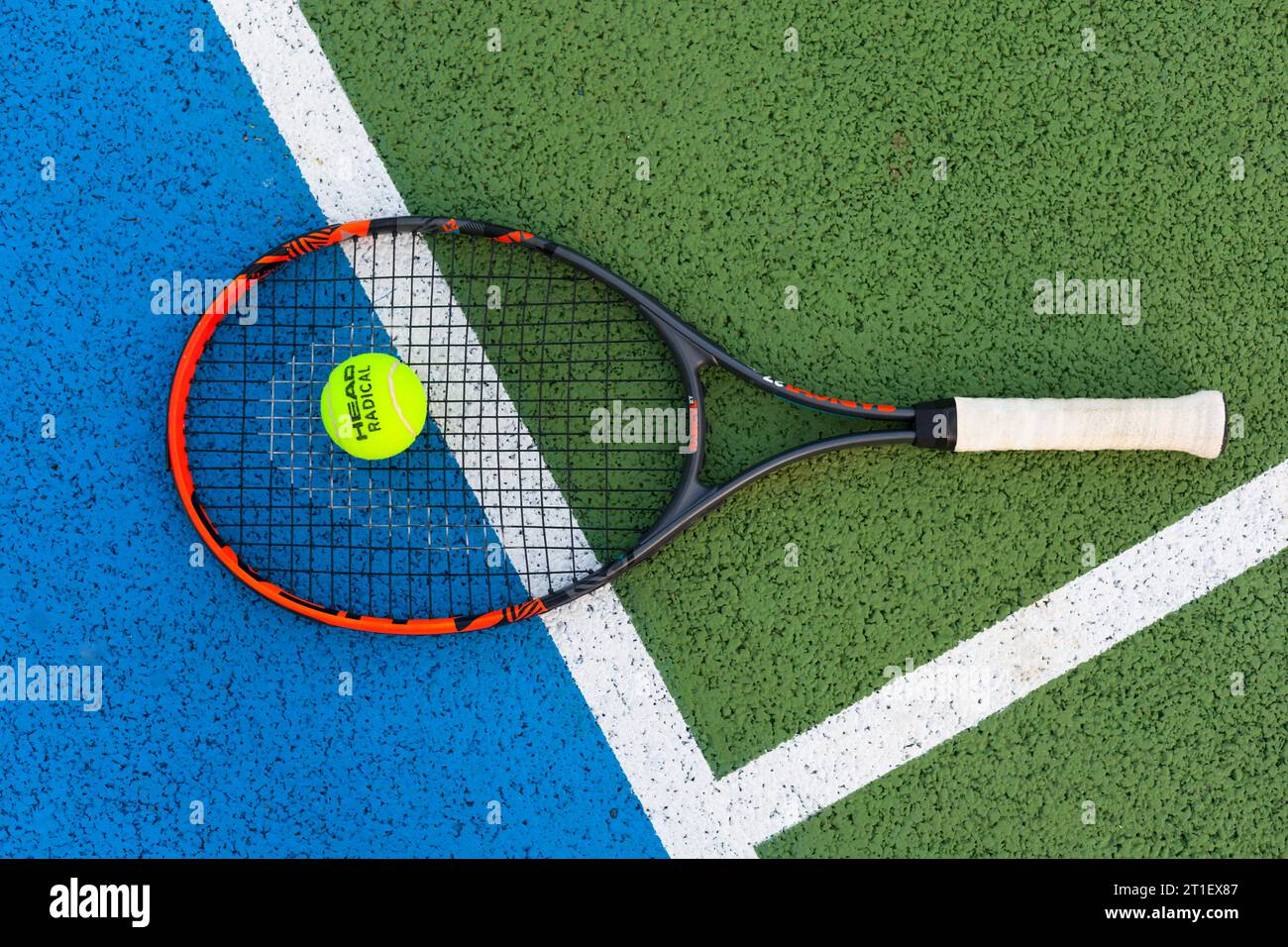 Head Tennisschläger mit Head-Logo-Ball quer über die Linie Stockfoto