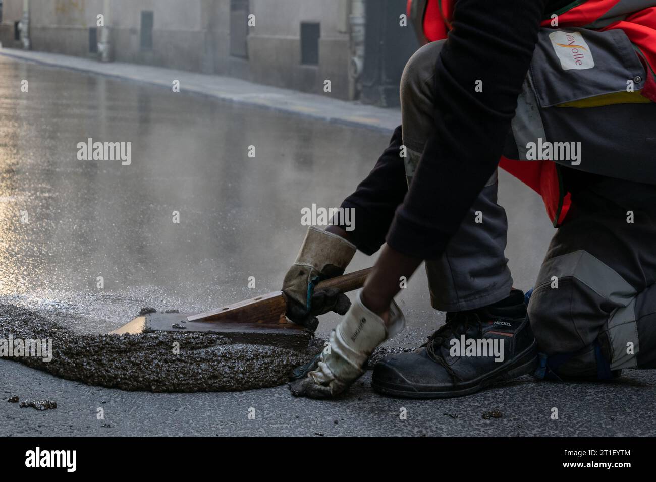 Hart arbeitender Arbeiter, der an einem Streiktag eine Straße in Frankreich restauriert Stockfoto