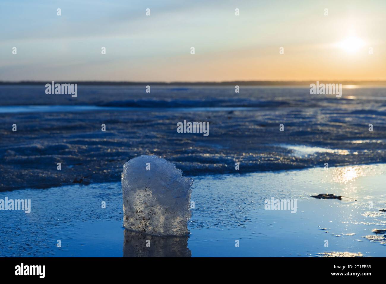 Winterlandschaft mit gefrorenem See. Eiswürfel liegt im Sonnenlicht auf einem Sonnenuntergang, natürliches Foto Stockfoto