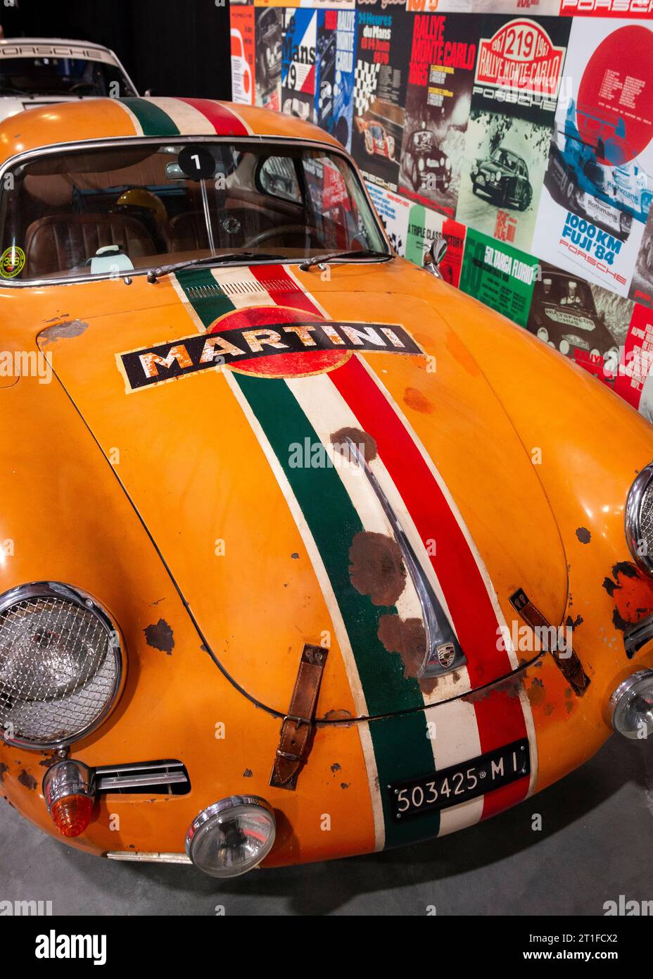 Vorderansicht des orangen Porsche 356 C 1600 Rennwagens aus dem Jahr 1964 mit italienischem Nummernschild, Martini-Emblem und italienischer Flaggenauflage Stockfoto