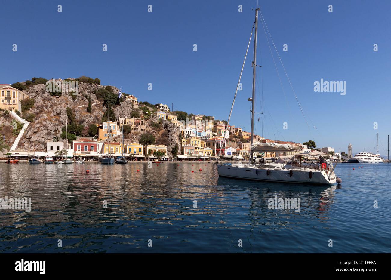 Weiße Vergnügungsyacht in der Bucht der Insel Symi an einem hellen sonnigen Tag. Simi. Griechenland. Stockfoto
