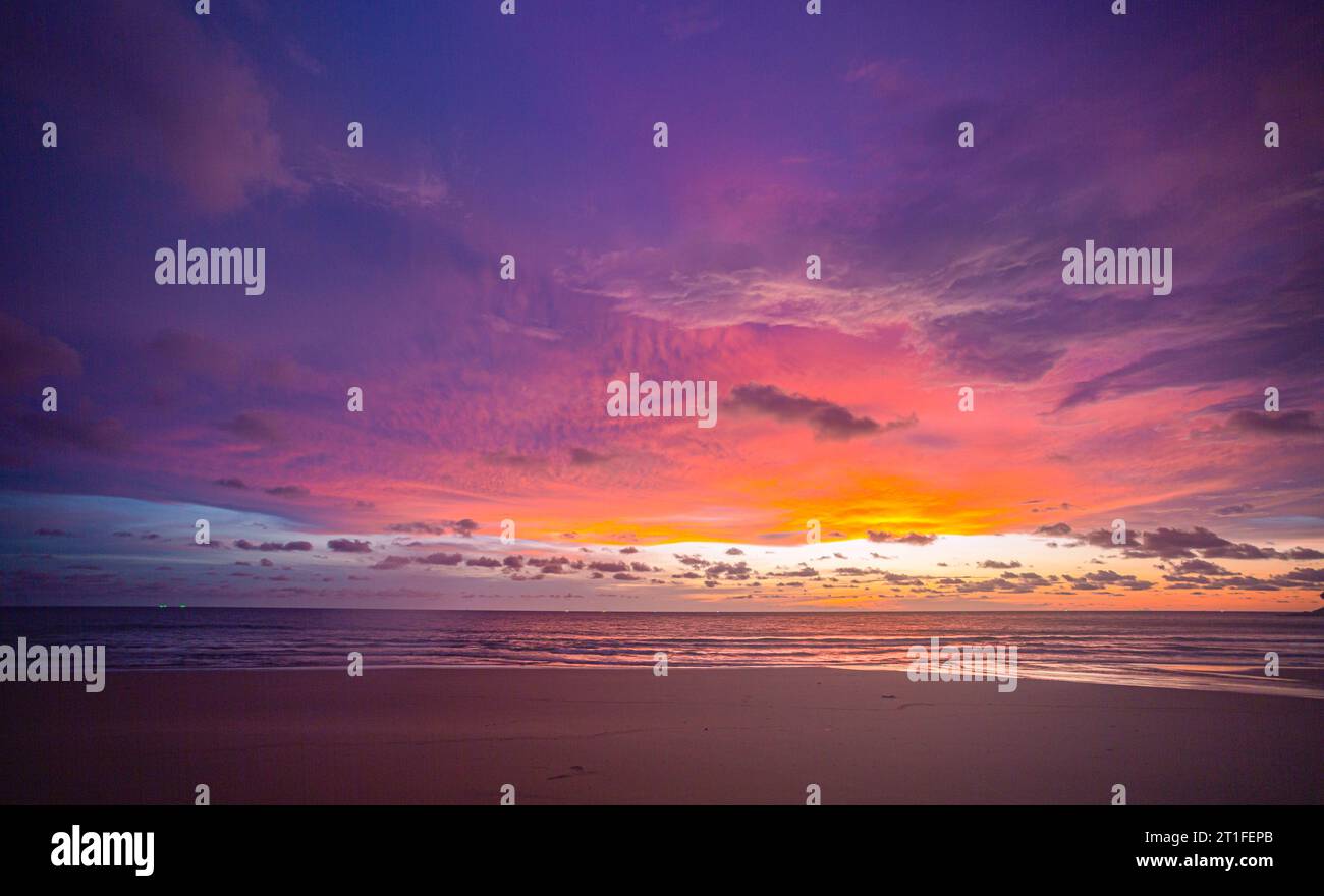 Machen Sie romantische rosa Himmel bei Sonnenuntergang über dem Ozean. Sonnenuntergang mit hellen roten Lichtstrahlen und anderen atmosphärischen Effekten. Farbenfrohe Wolke in hellem Himmel. Himmel Stockfoto