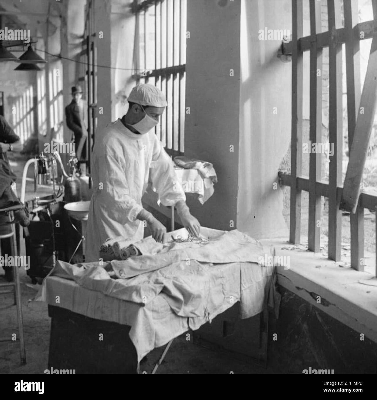 British Medical Services im Zweiten Weltkrieg Feld chirurgische Einheiten (FSU): Oberst W G Luxford von Pappel, East London, ein Krankenhaustechniker, bereitet das Instrument Tabelle, bevor ein Betrieb bei einer Fsu in einer viel bombardiert und beschossen italienisches Gefängnis, Dezember 1943. Der Bereich, in dem sie tätig sind, ist unter Feind shellfire. Stockfoto