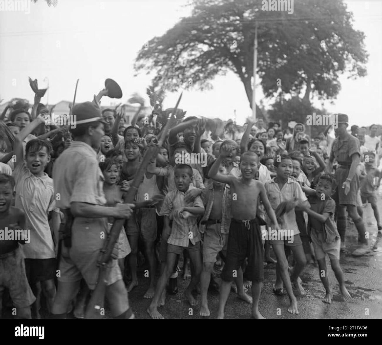 Britische Wiederbesetzung von Singapur, 1945 jubelnden Scharen junger Malaysier die Rückkehr der britischen Streitkräfte nach Singapur willkommen. Stockfoto