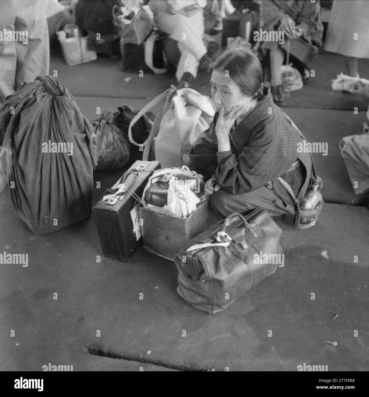 Die britische Wiederbesetzung von Hong Kong Eine ältere japanische Frau wartet gespannt am Hafen für den Transport, die Sie zu Stanley Camp, Hong Kong. Rund 3.000 japanische Zivilisten wurden von Kowloon nach Stanley Camp, das während des Krieges von der japanischen Besatzungsmacht als Internierungslager für Alliierte Zivilisten eingesetzt wurde verschoben. Stockfoto