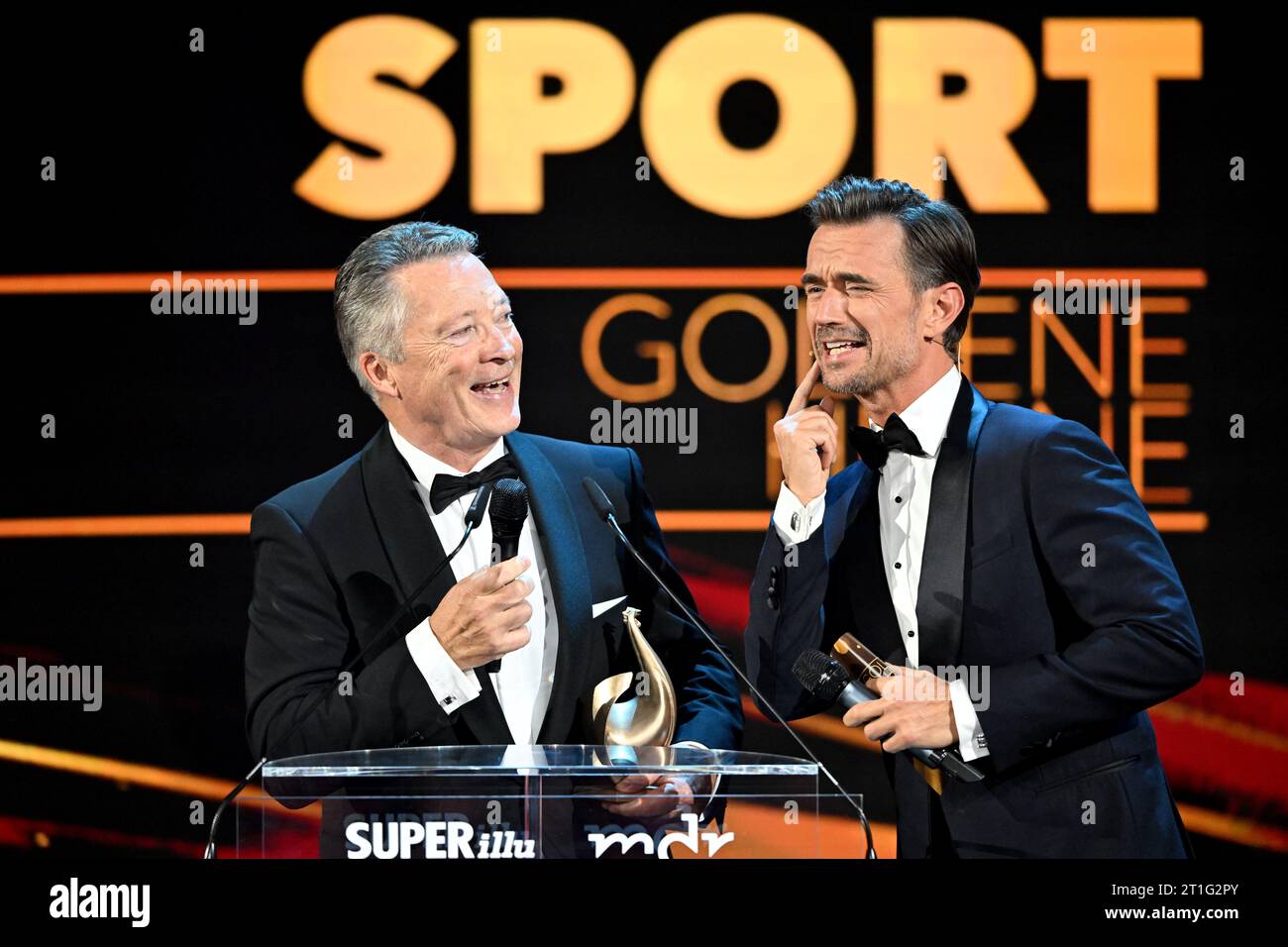 Leipzig, Deutschland. Oktober 2023. Nationaltrainer Harold Kreis (l) spricht bei der Medienpreisverleihung Goldene Henne mit Moderator Florian Silbereisen, nachdem er die Trophäe in der Sportkategorie gewonnen hat. Der Publikumspreis wird zum 29. Mal auf einer TV-Gala in Leipzig verliehen. Quelle: Hendrik Schmidt/dpa/Alamy Live News Stockfoto