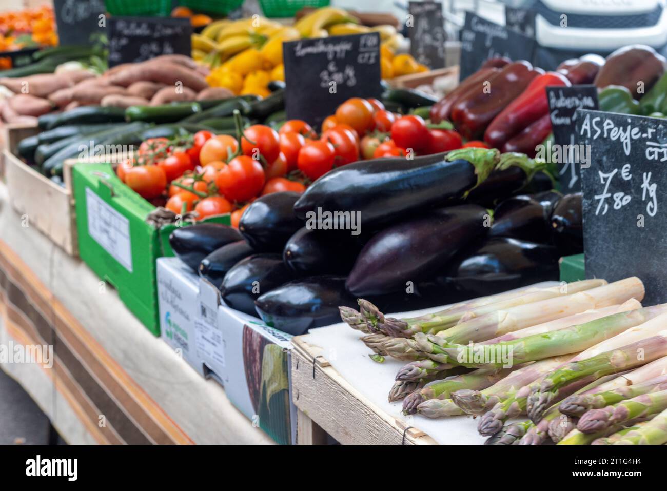 Spargel, Auberginen, rote Tomaten und anderes frisches Gemüse werden auf dem Markt im Freien in Arles, Provence, Südfrankreich, angeboten. Stockfoto