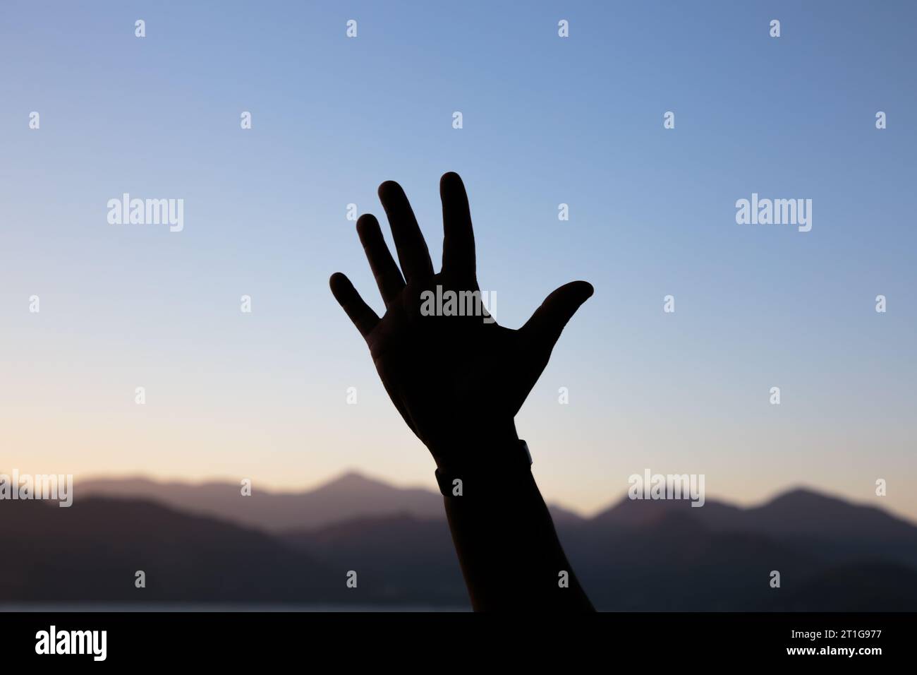 Silhouette der Hände in Form der Nummer fünf mit einem wunderschönen, farbenfrohen Nachmittagshimmel in Rio de Janeiro, brasilien. Stockfoto