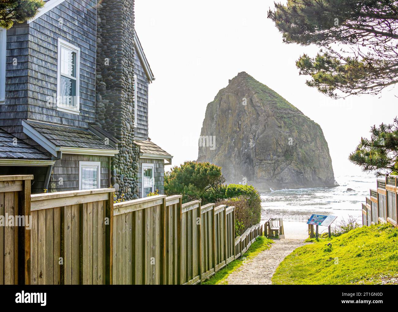 Ein Pfad zum Strand und Haystack Rock führt vorbei an einem Strandhaus in Cannon Beach, Oregon, USA. Stockfoto