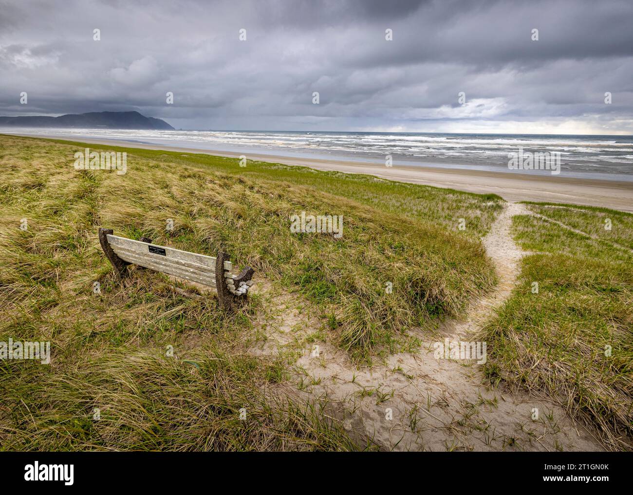 Eine Bank und ein Weg zum weiten offenen Strand von Gearhart an der Küste von Oregon, USA. Stockfoto