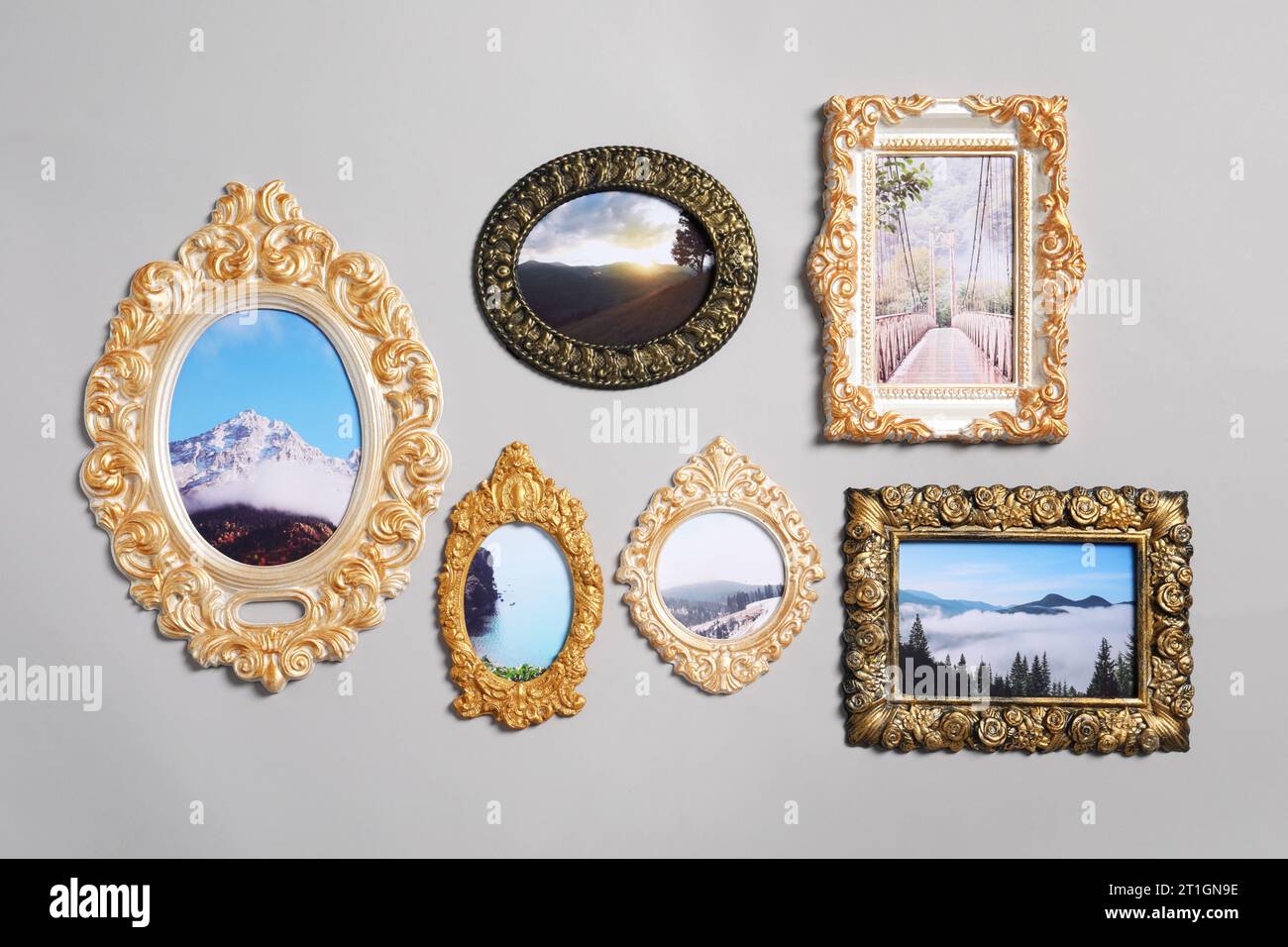 Vintage-Rahmen mit wunderschönen Fotos von Landschaften, die an einer hellgrauen Wand hängen Stockfoto