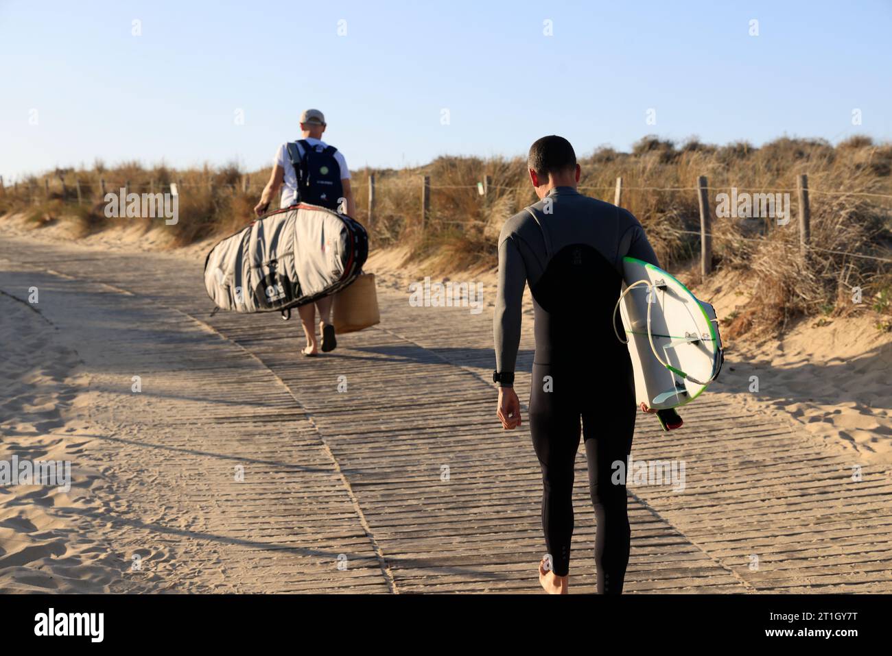 Surfer überqueren die Düne auf Pfaden, die für den Zugang zum Atlantischen Ozean ausgelegt sind. Im Südwesten Frankreichs hat die Aquitanische Küste Sanddünen entlang ca. Stockfoto