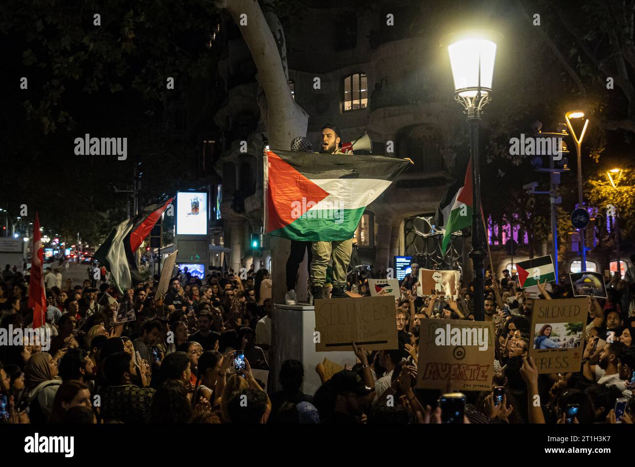 Barcelona, Spanien. Oktober 2023. Ein Demonstrant steht über der Menge propalästinensischer Menschen, während er während einer solidarischen Demonstration mit Palästina eine palästinensische Flagge schwenkt. Die palästinensische Diaspora und andere propalästinensische Demonstranten gingen in einer Demonstration auf die Straßen von Barcelona, um die Gewalt gegen das palästinensische Volk zu verurteilen und ein Ende der israelischen Apartheid zu fordern. (Credit Image: © Axel Miranda/SOPA Images via ZUMA Press Wire) NUR REDAKTIONELLE VERWENDUNG! Nicht für kommerzielle ZWECKE! Stockfoto