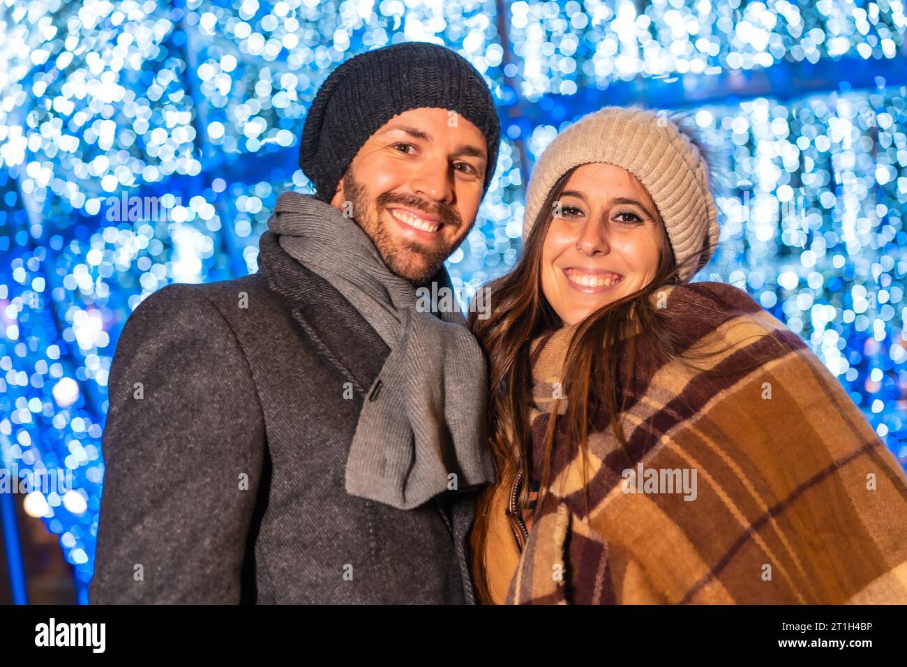 Ein junges europäisches Paar, das die Weihnachtsbeleuchtung der Stadt genießt Stockfoto