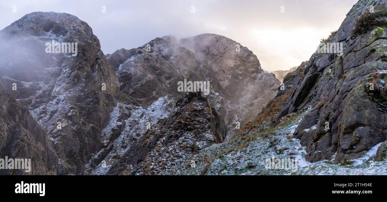 Ein junger Mann auf dem Gipfel des Berges im verschneiten Winteruntergang, auf dem Berg Penas de Aya in der Stadt Oiartzun bei San Sebastian, Gipuzkoa. Baskisch Stockfoto