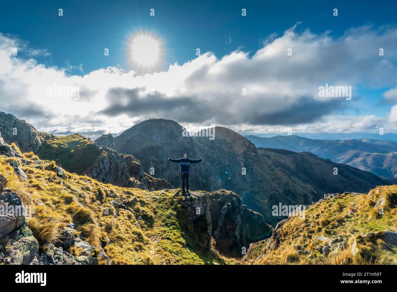 Ein junger Mann mit offenen Armen auf dem Berg Aiako Harria, Guipuzcoa. Baskenland Stockfoto