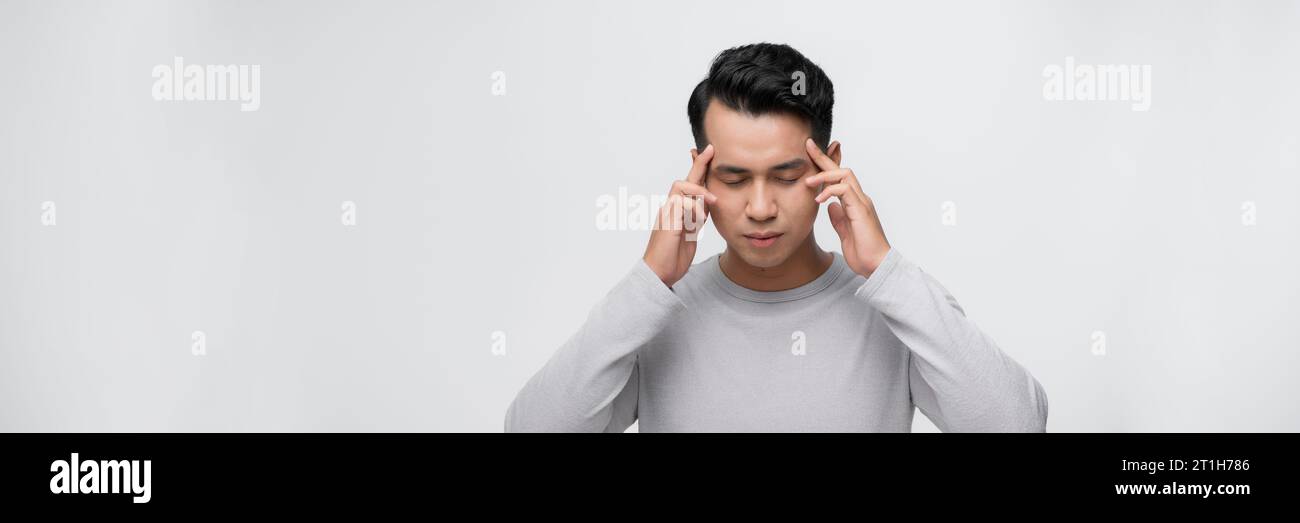 Hübscher asiatischer Mann mit Hand auf Kopf, Kopfschmerzen wegen Stress. Migräne leiden. Stockfoto