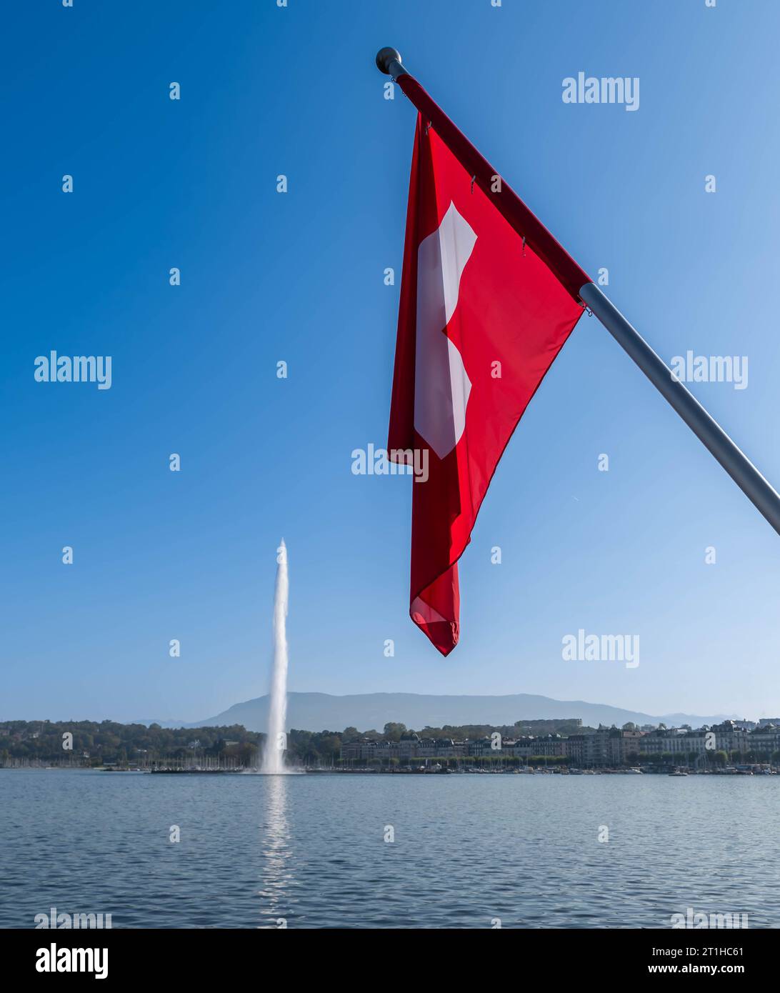 Genfs ikonischer Wasserstrahl und die Schweizer Flagge in Genf, Schweiz Stockfoto