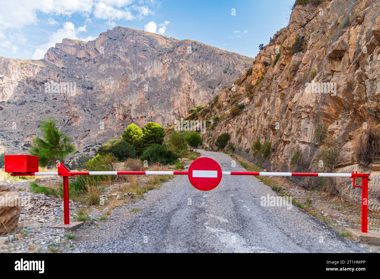 Barriere mit einem Schild ohne Eintritt mit einer asphaltierten Bergstraße, die im Hintergrund verschwindet. Stockfoto