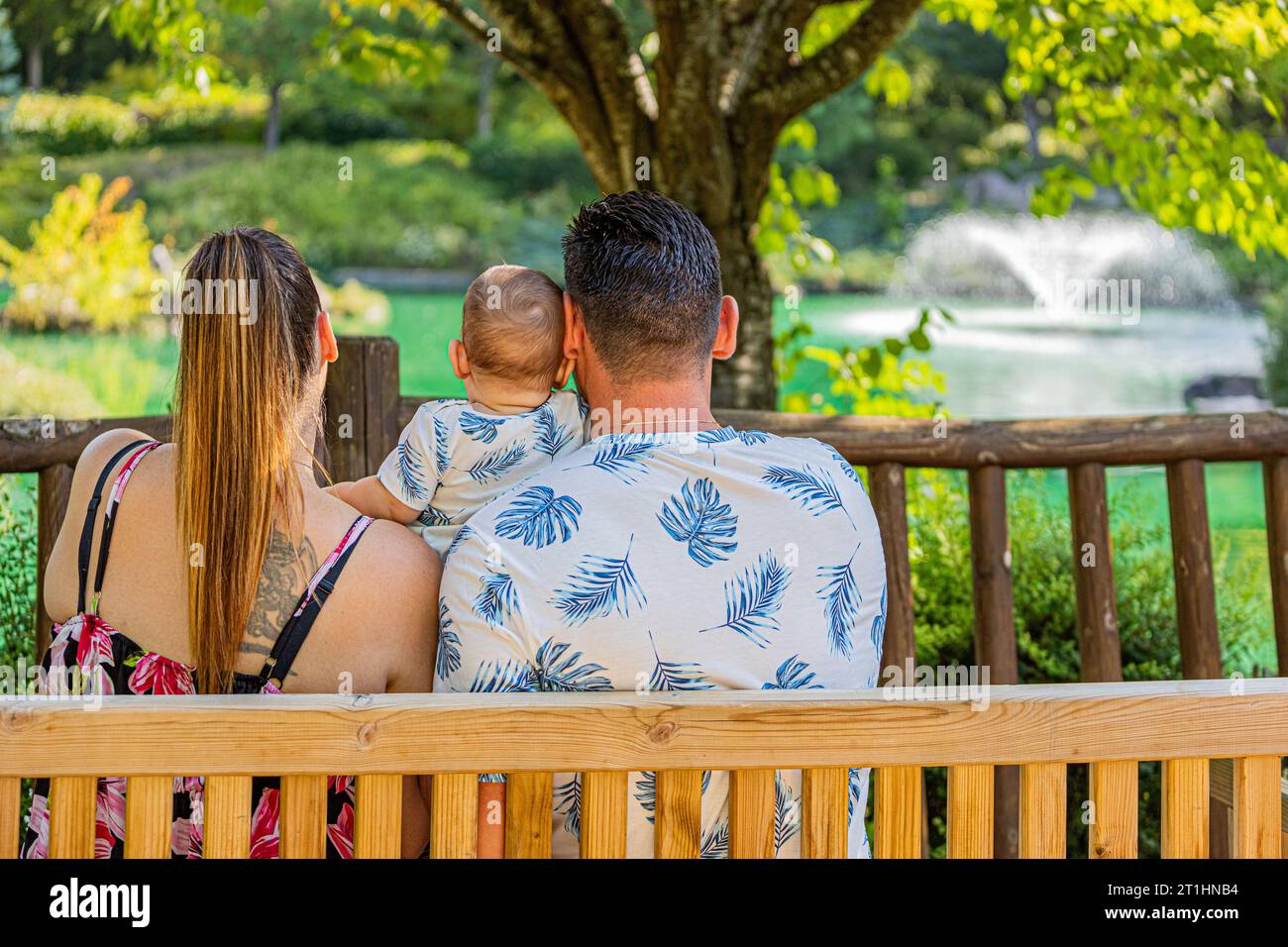 Eine Familie in Dijons japanischem Garten, ein Paar mit einem Baby, das auf einer Bank sitzt. Le jardin japonais à Dijon en famille, Couple avec un bébé assis sur un Stockfoto