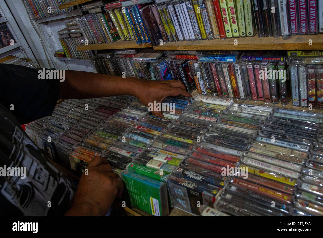 Bantul, Yogyakarta, Indonesien. Oktober 2023. Ein Ladenbesitzer bereitet in einem Musikgeschäft namens Toko Musik Luwes in Bantul physische Albumaufnahmen im Kassettenformat vor. Nach Angaben der Recording Industry Association of America (RIAA) steigen die Einnahmen aus Musik, die vor allem durch Streaming-Dienste, aber auch durch den Verkauf physischer Musikformate angetrieben werden. Der Bericht stellte fest, dass die Einnahmen aus physischen Musikformaten im Laufe der Jahre allmählich gestiegen sind. Der Gesamtumsatz für physische Musik stieg im vergangenen Jahr um 4 Prozent, angetrieben von einem 17-prozentigen Anstieg der Schallplatten. Physische Veröffentlichung von Musik Stockfoto