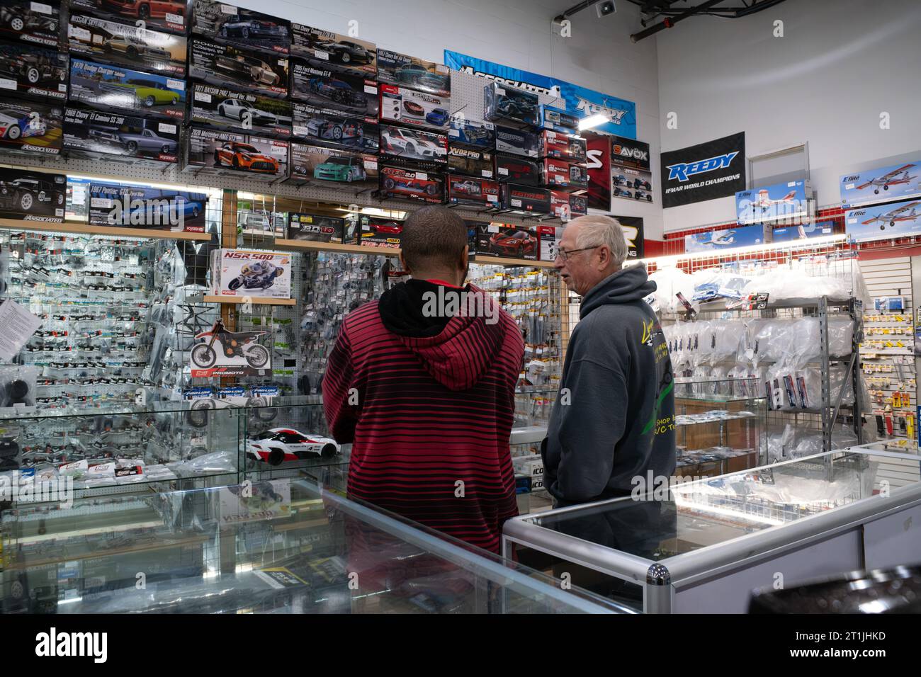 Ein Mitarbeiter, der einem Kunden in einem funkgesteuerten Hobby-Shop hilft Stockfoto