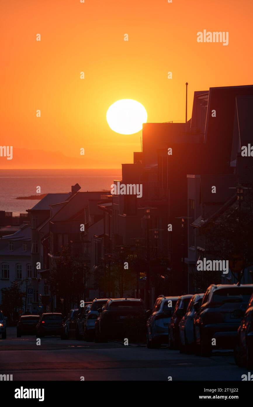 Wunderschöner Sonnenuntergang über dem Wohngebäude und Parkplatz am Straßenrand in Reykjavik Downtown Stockfoto