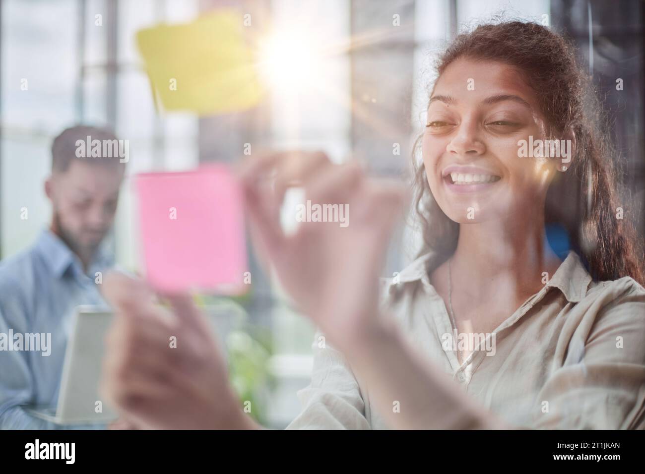 Ihre Vision zum Leben erwecken. Aufnahme einer selbstbewussten Geschäftsfrau, die ihrem Kollegen mit Haftnotizen an einer Glaswand im Büro eine Idee vorstellt. Stockfoto