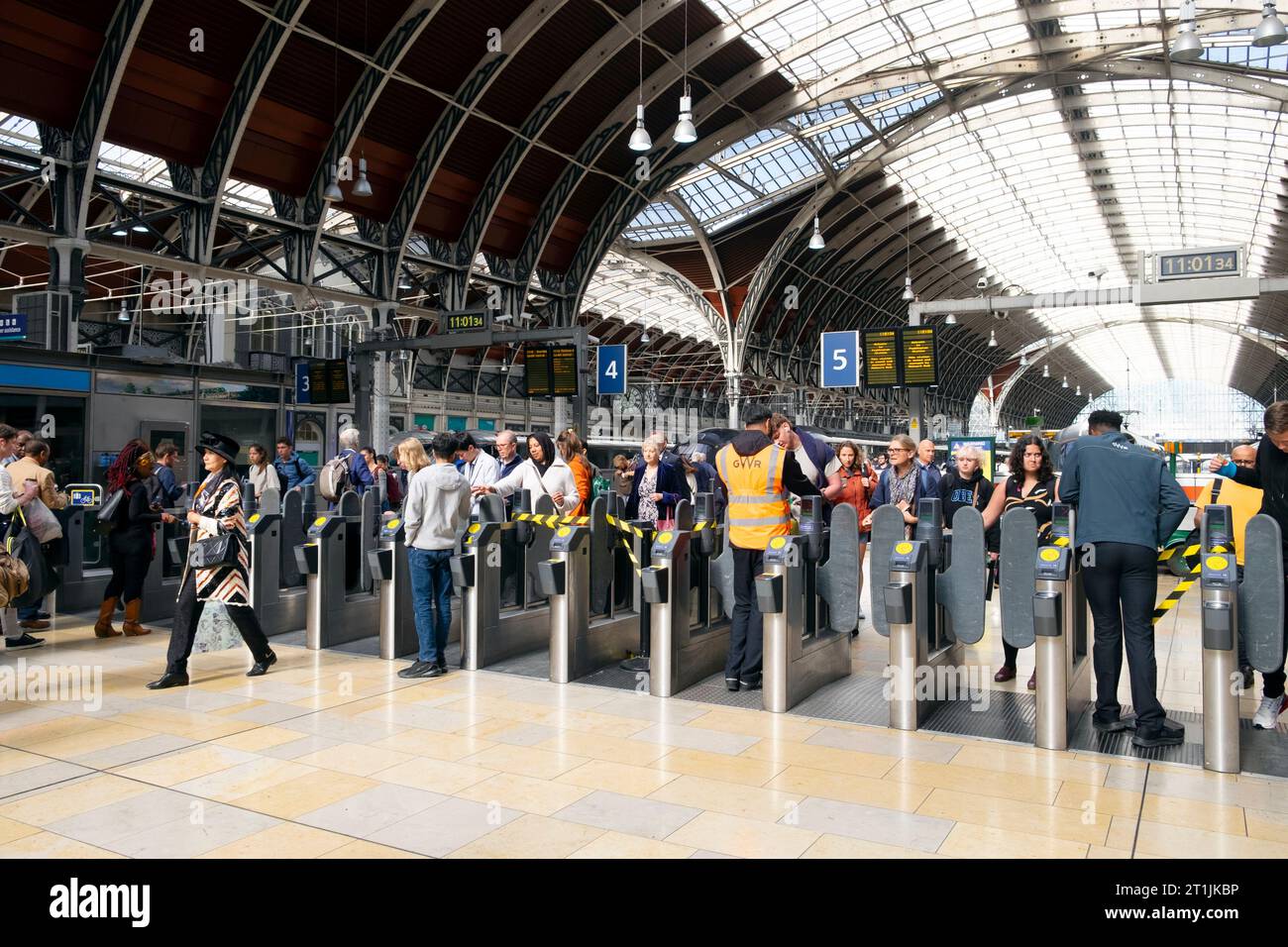 Passagiere Reisende, die durch Schranken am Fahrkartenautomaten fahren, wenn sie Züge und Bahnsteige verlassen, an der Paddington Station London UK 2023 KATHY DEWITT Stockfoto