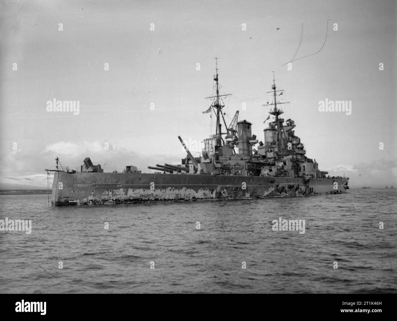 Die Royal Navy während des Zweiten Weltkriegs HMS KING GEORGE V stationär, Küstengewässer. Beachten Sie, dass der schlechte Zustand der Lackierung. Eine der Kanonen von Y Revolver bei maximaler Höhe. Stockfoto