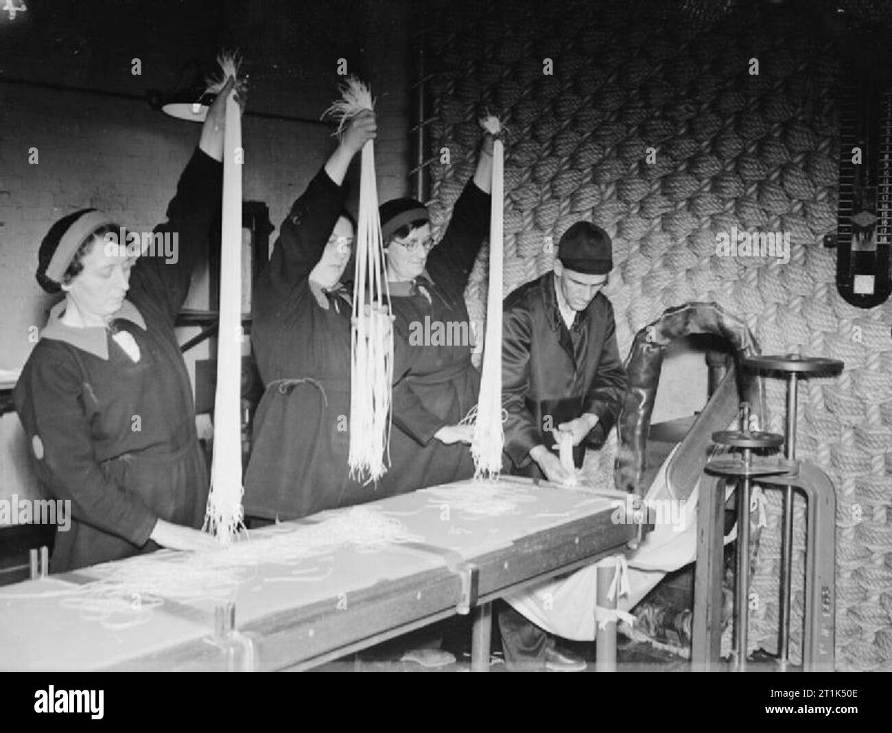 Krieg Industrie in Großbritannien 1939-1945 Kordit Produktion auf eine Royal Naval Rüstung Fabrik in Holton Heath. Die langen kordit werden von Frauen Arbeitnehmer gekämmt, um kurze Längen zu beseitigen. Stockfoto