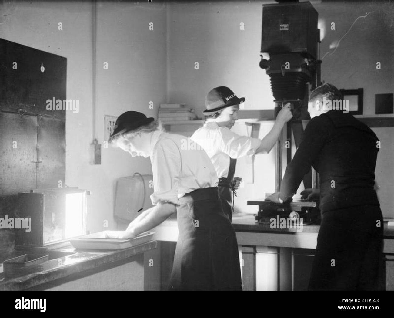 Wrens in der Ausbildung zu Fotoassistenten an der Royal Naval Air Station Donibristle, Fife, 1942 in der Dunkelkammer erhalten die Wrens Anweisungen zum Vergrößern und entwickeln von Abzügen. Stockfoto