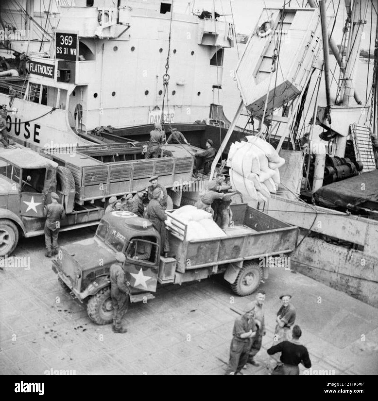 Verbrauchsmaterial entladen von einem Schiff im Mulberry künstlichen Hafen von Arromanches in der Normandie, Juli 1944. Löschen eines Schiffes bei Mulberry B, Juli 1944. Stockfoto