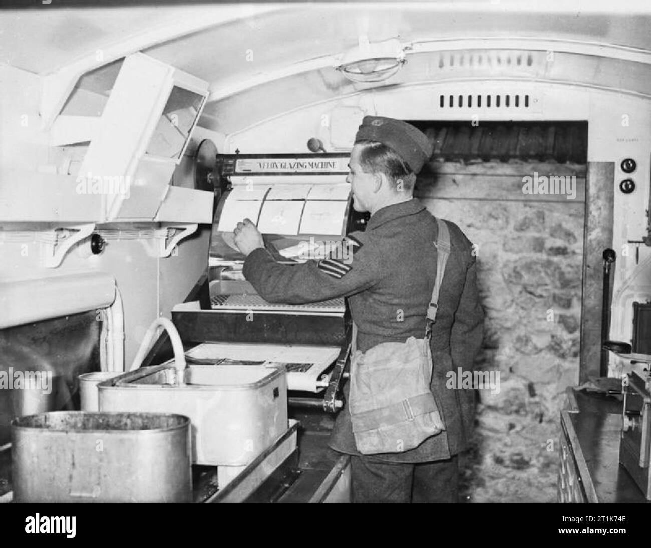 Während des Zweiten Weltkriegs verglaste der Sergeant, der für die Fotografie-Sektion in Bétheniville, Frankreich, Luftaufklärungsabdrücke in einem Mobile Darkrooms-Tender. Stockfoto