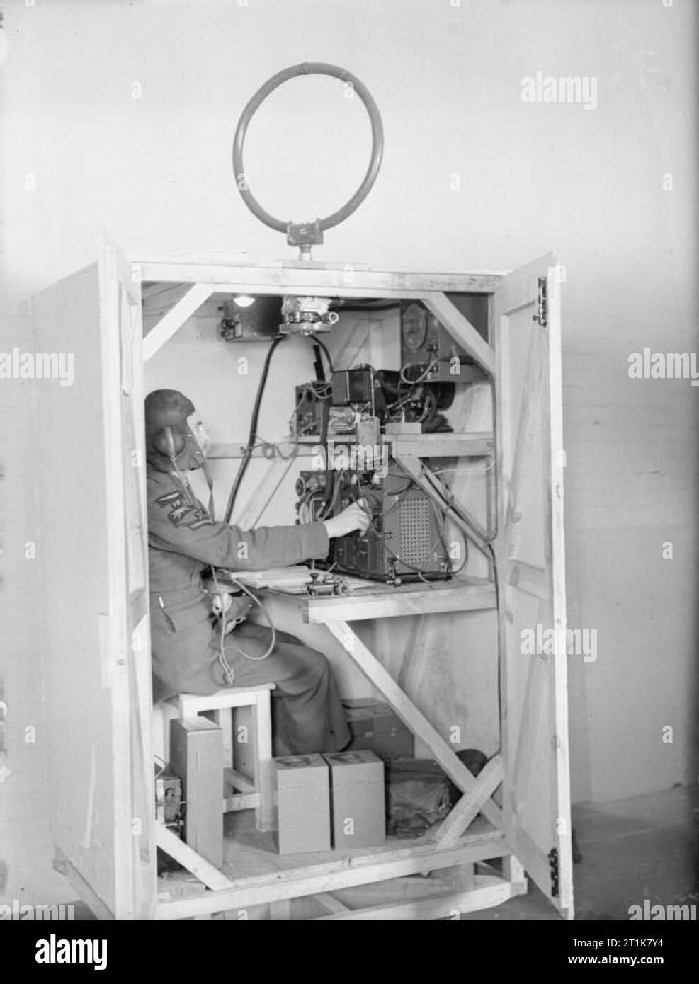 Royal Air Force Bomber Command, 1939-1941. Ein wireless Operator arbeitet seine T1083/R1082 Sender/Empfänger einrichten, sitzen in einem hölzernen Attrappe eines Wireless-Position des Fahrers in einem Armstrong Whitworth Whitley, an Nr. 10 betriebliche Ausbildung Einheit, Abingdon, Berkshire. Sein set ist in eine Richtung angeschlossen (D/F) loop Antenne auf der Oberseite des Motorraums. Stockfoto