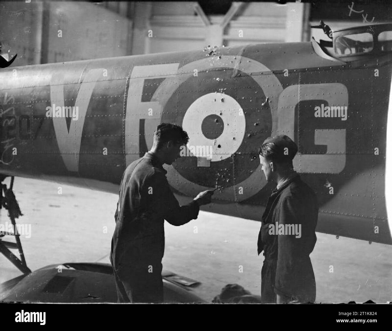 Royal Air Force Bomber Command, 1939-1941. Rigger prüfen Sie die exit-Löcher von feindlichen Maschinengewehr Kugeln im Rumpf der Bristol Blenheim Mark IV, N6207 - G "der Nr. 110 Squadron RAF während der Reparatur in einem Hangar am Wattisham, Suffolk. Stockfoto