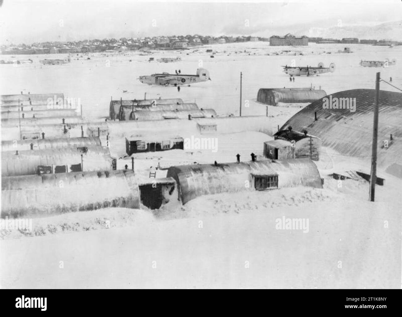 Royal Air Force Coastal Command, 1939-1945. Snowed-technische Hütten und Flugplatz in Reykjavik, Island, während einer Flaute im Blizzard, die die Insel zwischen dem 21. und 27. Februar 1945 getroffen. Konsolidierte Befreier GR Markierung gegenüber der Nr. 53 Squadron RAF sind auf dem Flugplatz geparkt. Stockfoto