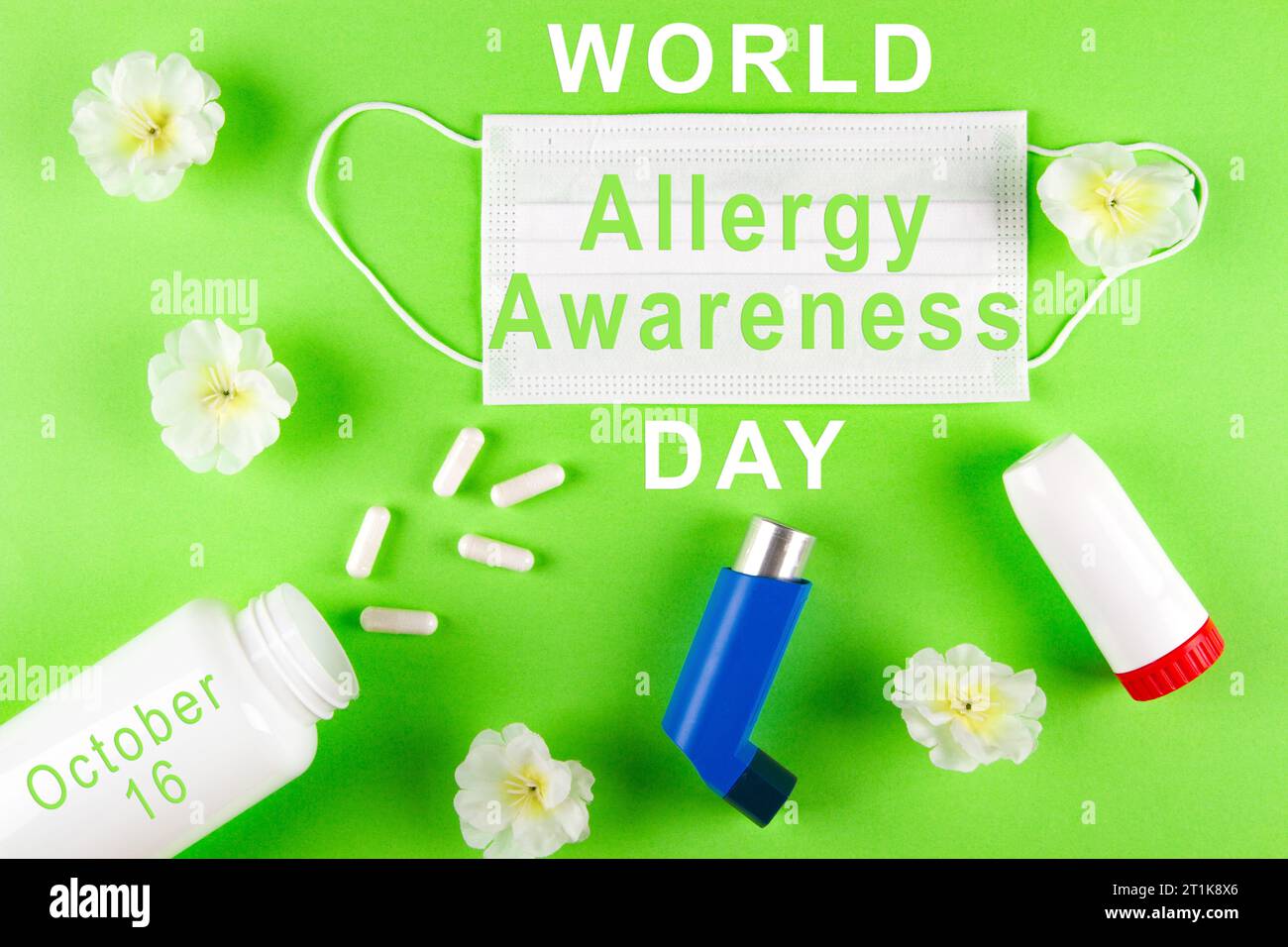 Weltallergie-Awareness-Tag am 16. Oktober. Poster mit weißer Inschrift, OP-Maske, Blumen, Inhalatoren und Flasche mit Pillen auf lebendigem Pl Stockfoto